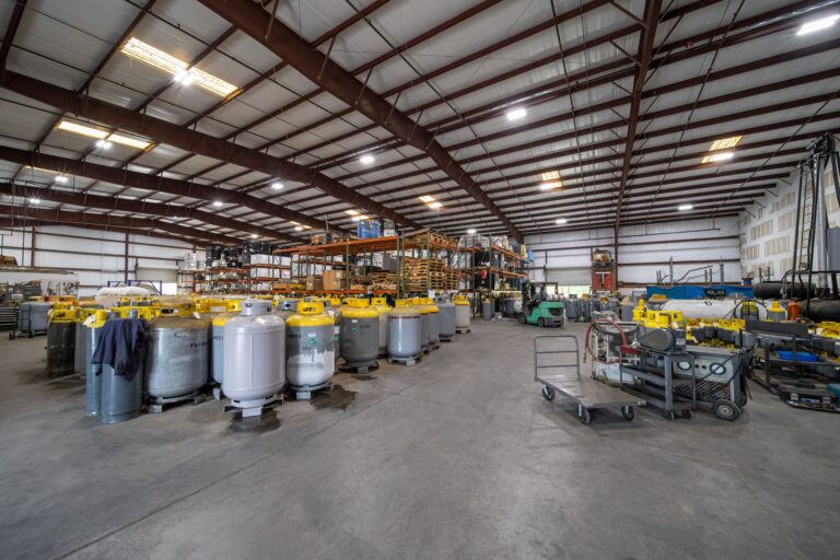 Warehouse filled with large volume refrigerant recovery cylinders and inventory demonstrating supply capacity.