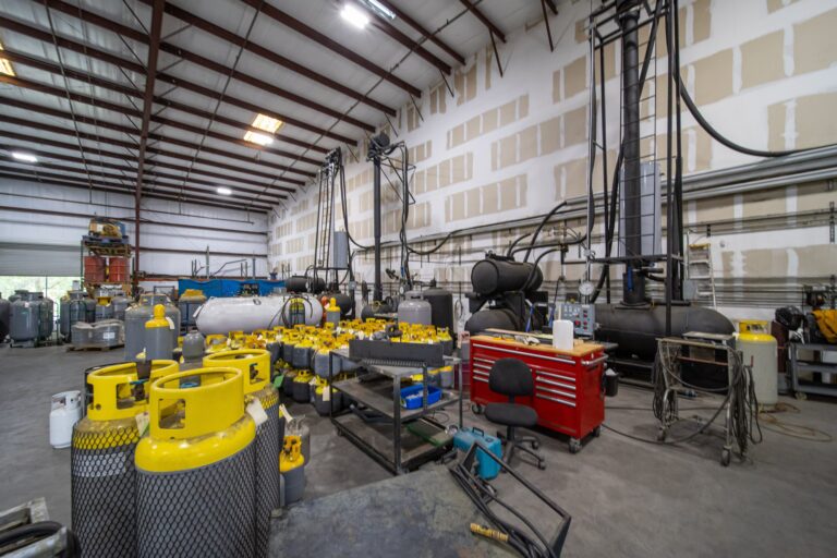 Interior of American Refrigerants facility showing industrial distillation towers and large scale recovery tanks.
